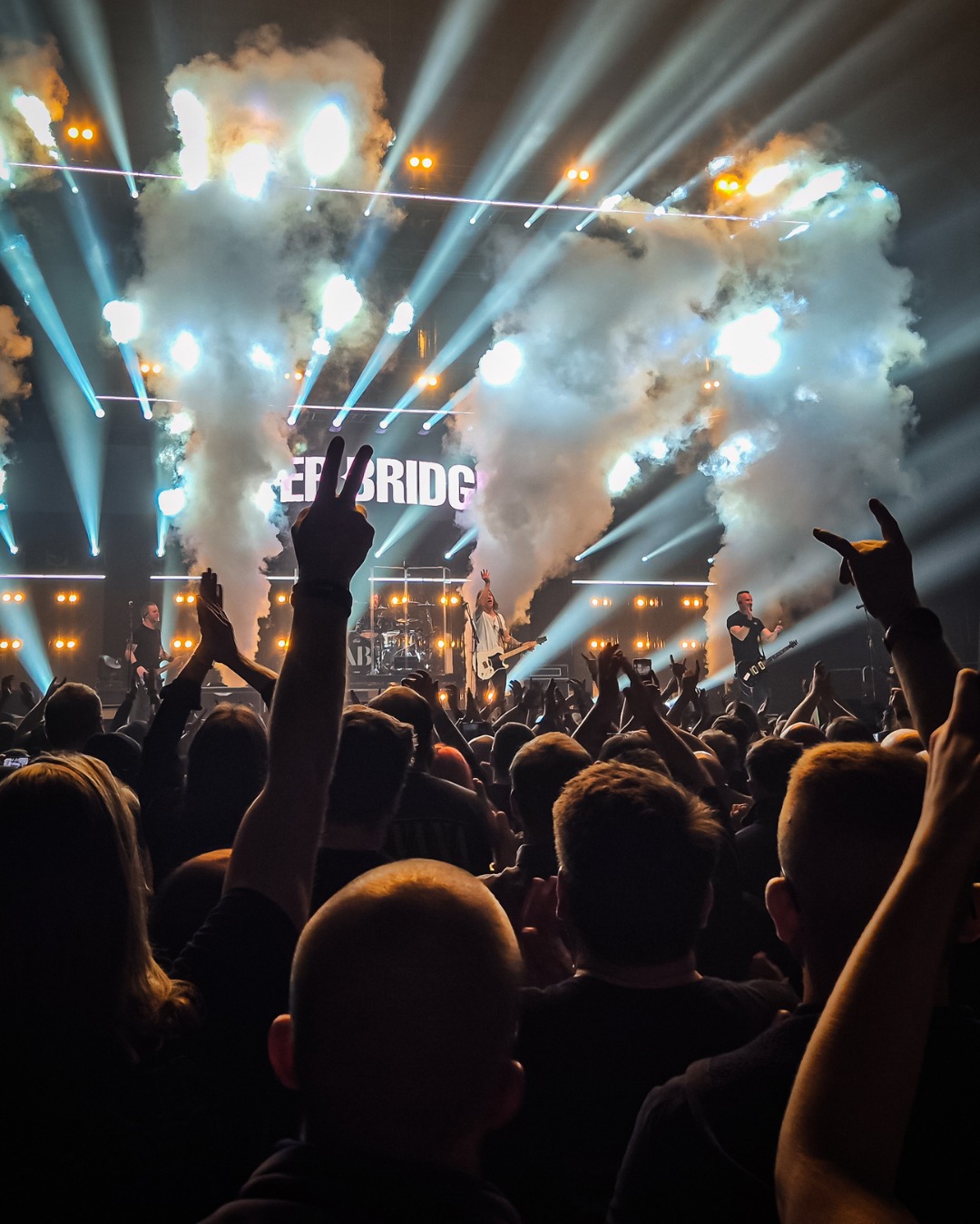 Live music photography — a concert crowd beneath stage smoke and lights